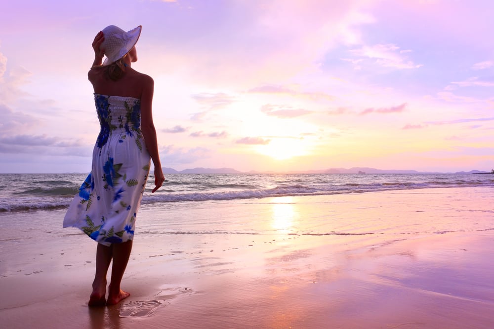 womaninhatwalkingonbeach